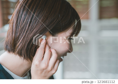 ワイヤレスイヤホンをつける女性 121681112