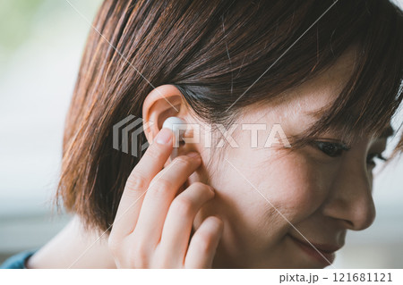 ワイヤレスイヤホンをつける女性 121681121