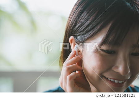 ワイヤレスイヤホンを使う女性 121681123