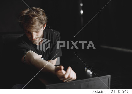 Man addicted to drugs. Bad habit concept. Taking injection in dark room. 121681547