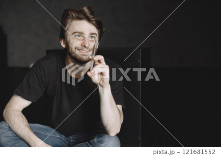 Drug addiction concept. Young sick drug addict man. He is sitting alone and about to take a dose. 121681552