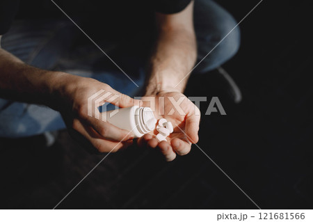 Depressed man suffering from suicidal depression. Want to commit suicide by taking strong medicament drugs and pills Depressed man suffering from suicidal depression. Want to commit suicide by taking strong medicament drugs and pills 121681566
