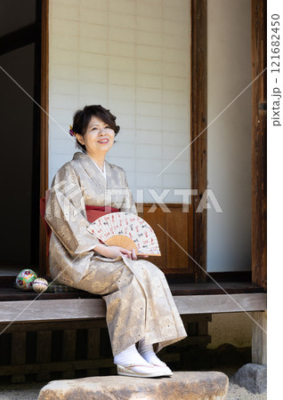 縁側で扇子をもって座っている女性 121682450