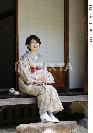縁側で扇子をもって座っている女性 121682451