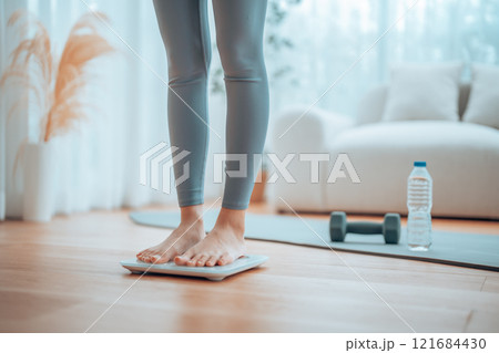 Closeup of feet, Young Asian woman standing on scales to measure her weight at home 121684430