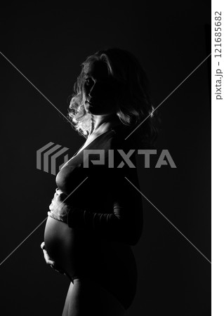 silhouette of a pregnant girl shooting on the background in the studio 121685682
