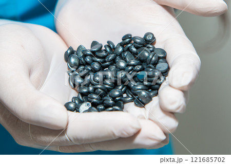 Wax for depilation of grey color in hands in gloves. Wax for depilation of grey color in hands in gloves. 121685702