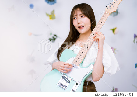 エレキギターを持つロングヘアの若い女性 エレキギターを持つロングヘアの若い女性 121686401