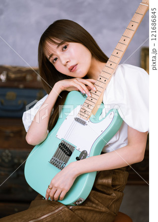 エレキギターを持つロングヘアの若い女性 エレキギターを持つロングヘアの若い女性 121686845