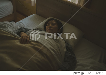 ベッドで眠る若い女性 121686953