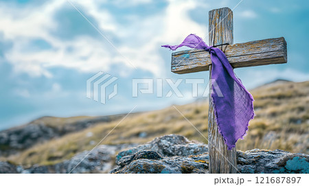 Wooden cross with a purple ribbon tied to it 121687897