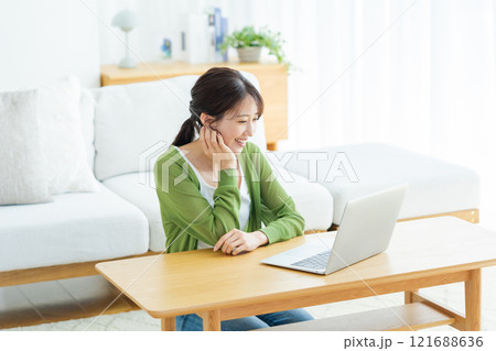 自宅でノートパソコンを操作する若い女性 121688636