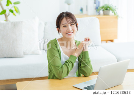 自宅でノートパソコンを操作する若い女性 自宅でノートパソコンを操作する若い女性 121688638