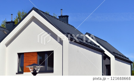 Terraced family homes in newly developed housing estate. The real estate market in the suburbs. New single family houses in a new development area. Residential homes with modern facade.  121688668