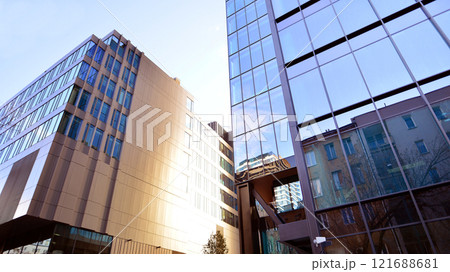 Looking up at the commercial buildings in downtown. Modern office building against blue sky. Windows of a modern glass building. Looking up at the commercial buildings in downtown. Modern office building against blue sky. Windows of a modern glass building. 121688681