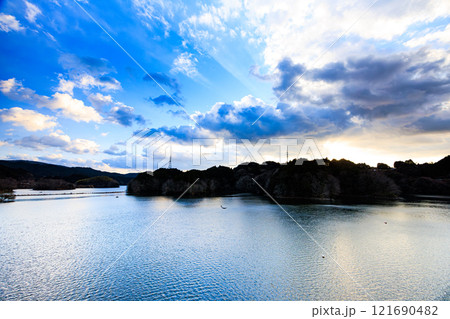 2025年新春寒風吹きすさぶ布目ダム南側夕景 日没前黄金色に染まり始めた山際の夕焼け 2025年新春寒風吹きすさぶ布目ダム南側夕景 日没前黄金色に染まり始めた山際の夕焼け 121690482