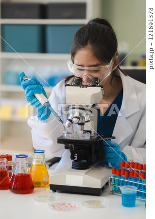 Female biotechnologist testing new chemical substances in a laboratory. Female biotechnologist testing new chemical substances in a laboratory. 121691378