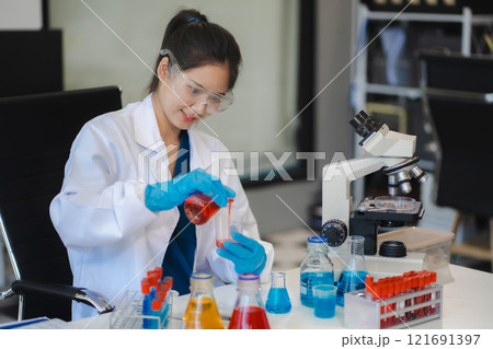 Female biotechnologist testing new chemical substances in a laboratory. 121691397