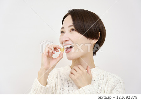 のど飴を舐める女性　白背景 121692879