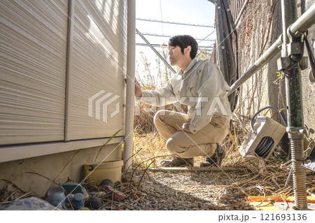 戸建て家屋の外壁重ね張りリフォーム工事の男性現場監督者 121693136