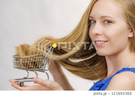 Girl with her long hair in shopping cart Girl with her long hair in shopping cart 121693368