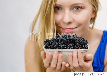 Girl holds blackberry fruits 121693373