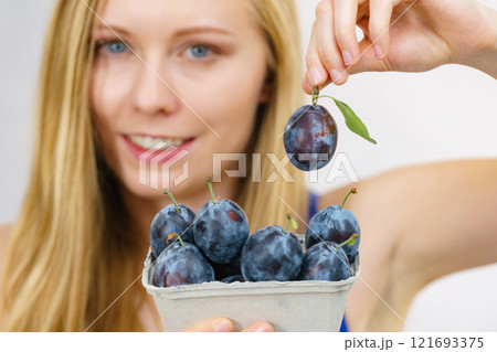 Girl holds plum fruits 121693375