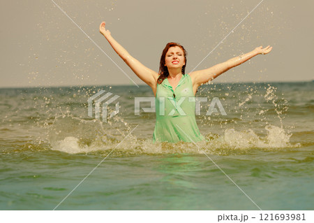 Redhaired happy girl on beach. 121693981