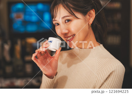 日本酒を試飲する若い女性【撮影協力・新潟地酒 premium SAKE 蔵KURA】 日本酒を試飲する若い女性【撮影協力・新潟地酒 premium SAKE 蔵KURA】 121694225
