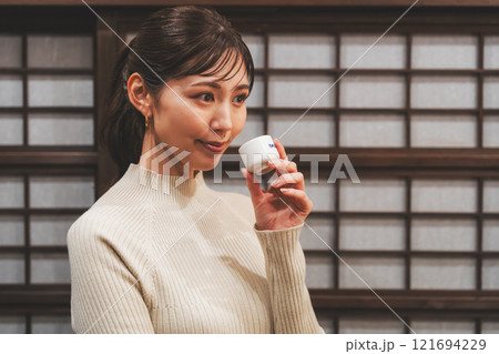 日本酒を試飲する若い女性【撮影協力・新潟地酒 premium SAKE 蔵KURA】 121694229
