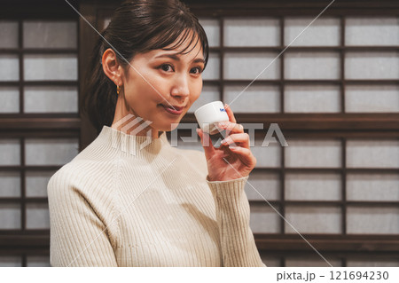 日本酒を試飲する若い女性【撮影協力・新潟地酒 premium SAKE 蔵KURA】 日本酒を試飲する若い女性【撮影協力・新潟地酒 premium SAKE 蔵KURA】 121694230