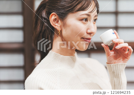 日本酒を試飲する若い女性【撮影協力・新潟地酒 premium SAKE 蔵KURA】 日本酒を試飲する若い女性【撮影協力・新潟地酒 premium SAKE 蔵KURA】 121694235