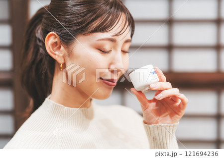 日本酒を試飲する若い女性【撮影協力・新潟地酒 premium SAKE 蔵KURA】 121694236