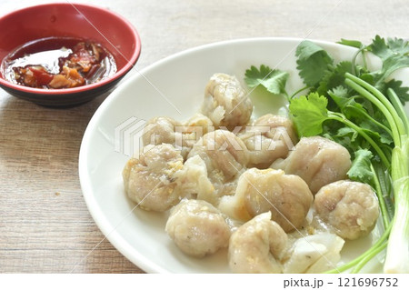 steamed fish dumpling with parsley and spring onion on plate dipping spicy sour sauce  121696752