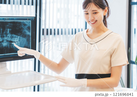 レントゲン写真で歯の状態を説明をする若い女性 レントゲン写真で歯の状態を説明をする若い女性 121696841