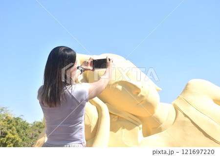 woman photo ancient reclining Buddha at Lokaya Sutha after renovate painting colors from white to yellow  121697220