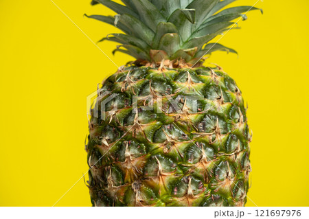 One fresh ripe pineapple fruit on a yellow background copy space for text. One fresh ripe pineapple fruit on a yellow background copy space for text. 121697976