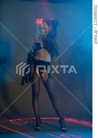 Stylish model posing in a futuristic setting with neon lights at night 121698582