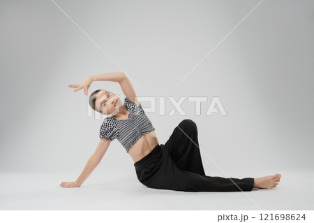 Girl showcasing flexible dance moves in a modern art studio setting 121698624