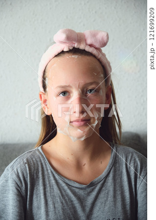 girl with a cosmetic mask on her face 121699209