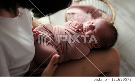 Newborn Photographer Swaddles A Baby During A Studio Photoshoot Newborn Photographer Swaddles A Baby During A Studio Photoshoot 121699578