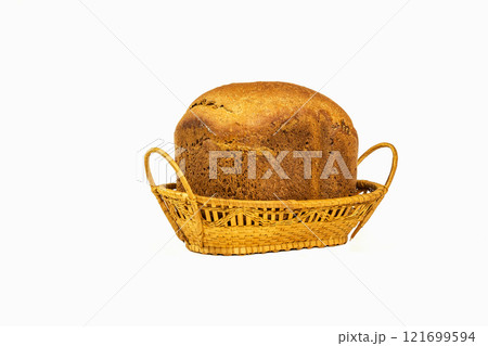 On a white background stands Wicker basket with a loaf of bread on a white background On a white background stands Wicker basket with a loaf of bread on a white background 121699594