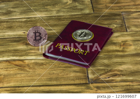 Bitcoin gold coin and the passport on a wooden surface 121699607