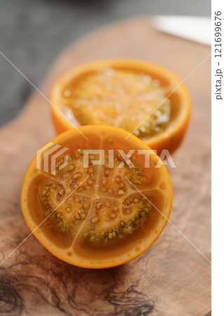 Lulo fruit sliced in halves on olive wood board on kitchen countertop 121699676