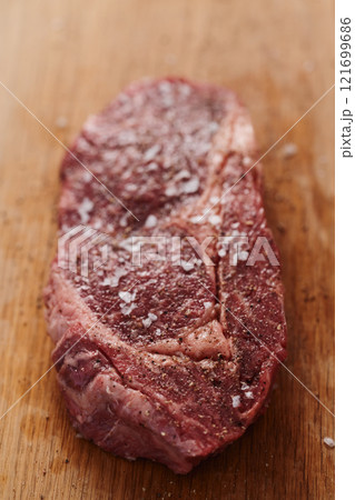 Raw ribeye steak spiced and ready to cook on oak board 121699686