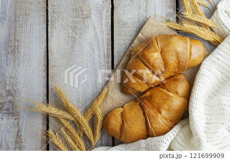 Coffee with croissants. Baked crispy croissant on a wooden board, breakfast. Homemade Croissant . 121699909