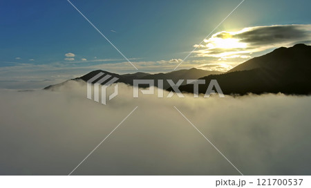 Aerial view of clouds and mountains at sunrise 121700537