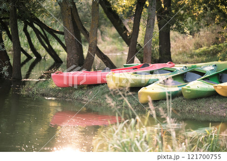 Many canoes of different colors on the river bank before training without people. Boating on the city river 121700755