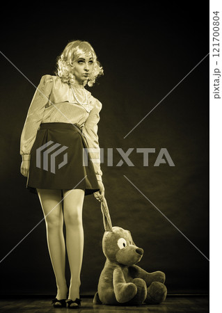childlike woman with dog toy on black childlike woman with dog toy on black 121700804