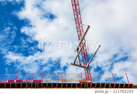 Crane and crane hook close up against blue sky 121702285